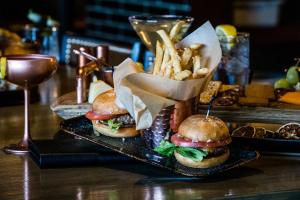 two hamburgers and french fries on a table with a drink at Hotel Lex and Conference Center, Trademark Collection in Lexington