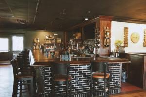 a bar with black stools in a restaurant at Hotel Lex and Conference Center, Trademark Collection in Lexington