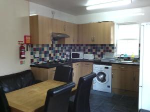 a kitchen with a table and a washing machine at Amazon Guest House in Oxford