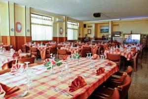 una habitación llena de mesas y sillas con manteles rojos en Hotel Casa Del Gourmet, en Siderno Marina
