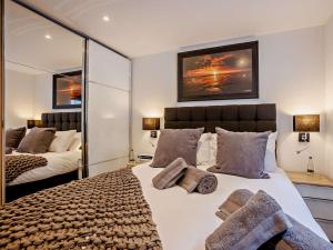 um quarto com uma cama grande e um espelho grande em 4 Bed in Westward Ho 86640 em Bideford