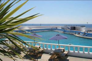 a large swimming pool next to the ocean at Spacious 2 Bedroom Apartment near Seafront in Penzance