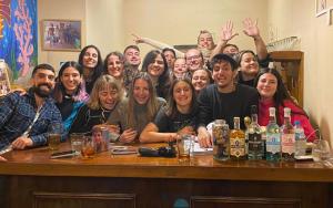a group of people posing for a picture at a table at Parla Hostel in Buenos Aires