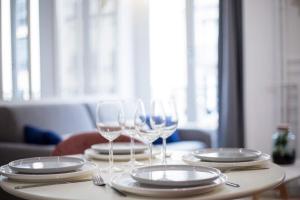 einen Tisch mit Weingläsern und Tafeln darauf in der Unterkunft Appartement cosy proche Arc de Triomphe - 4P in Paris