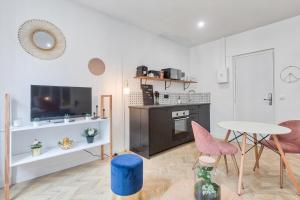 a living room with a table and pink chairs at Appartement cosy proche Arc de Triomphe - 4P in Paris