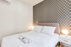 a bedroom with a white bed with two towels on it at Appartement cosy proche Arc de Triomphe - 4P in Paris