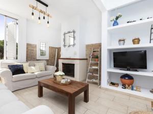 ein Wohnzimmer mit einem Sofa und einem TV in der Unterkunft CASA MODERNISTA CON PISCINA CANYET in Barcelona