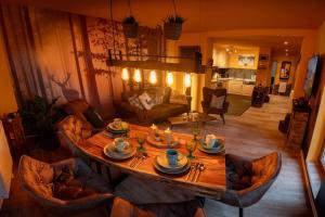 a living room with a wooden table and chairs at The Bridge - between NewZealand & OreMountains in Eibenstock