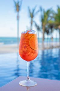 una copa con una bebida naranja frente a la piscina en Beach Park Resort - Acqua, en Aquiraz