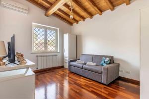 een woonkamer met een bank en een televisie bij Oliveto Relax Alloggio Turistico in Rome