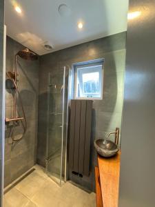 een badkamer met een wastafel en een douche bij Romantic Dutch hideaway in Jisp