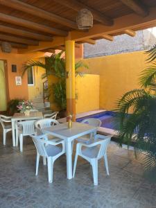 eine Terrasse mit Tischen und Stühlen und einem Pool in der Unterkunft Hotel Las Salinas in Zihuatanejo
