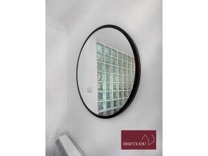 Bracknell - 1 Bedroom House With Garden في براكنيل: مرآة معلقة على جدار في الحمام