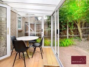 a patio with a white pergola and a table and chairs at Bracknell - 1 Bedroom House With Garden in Bracknell +4 photos