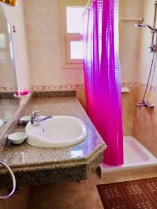 沙姆沙伊赫的住宿－Apartment in Sharks bay oasis 2 bedroom Private free beach，一间带水槽和粉红色淋浴帘的浴室
