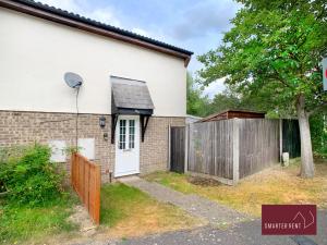 a house with a wooden gate and a fence at Bracknell - 1 Bedroom House With Garden in Bracknell