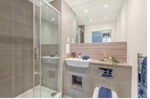 a bathroom with a sink and a glass shower at UPPAMOST luxury home 3 in Dagenham