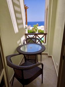 沙姆沙伊赫的住宿－Apartment in Sharks bay oasis 2 bedroom Private free beach，海景阳台上的桌椅