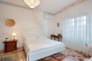 a bedroom with a white bed and a window at BB 1987 Pula in Pula