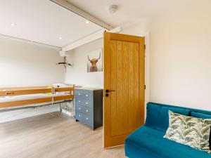 ein Schlafzimmer mit einem blauen Sofa und einem Etagenbett in der Unterkunft 2 Bed in Alcester 88397 in Coughton
