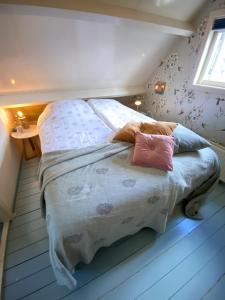 een bed met twee kussens in een slaapkamer bij Romantic Dutch hideaway in Jisp