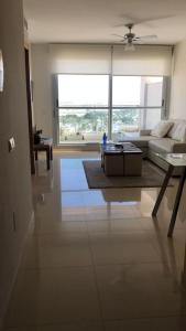 uma sala de estar com um sofá e uma mesa em Apartamento Deluxe: hidromasaje, terraza y vistas. em Las Hortichuelas