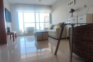 uma sala de estar com um sofá e uma mesa de vidro em Apartamento Deluxe: hidromasaje, terraza y vistas. em Las Hortichuelas