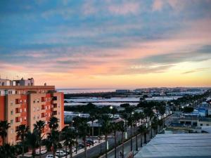 uitzicht op een stad met palmbomen en gebouwen bij Apartamento Deluxe: hidromasaje, terraza y vistas. in Las Hortichuelas