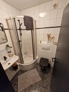 uma casa de banho com um chuveiro, um WC e um lavatório. em schicke und moderne Unterkunft nähe Messe Düsseldorf em Dusseldorf