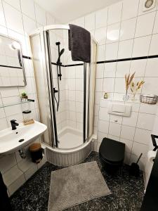 uma casa de banho com um chuveiro, um WC e um lavatório. em schicke und moderne Unterkunft nähe Messe Düsseldorf em Dusseldorf