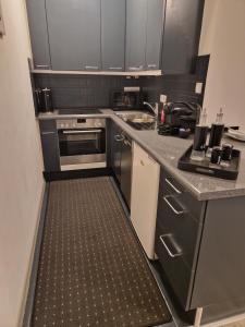 a kitchen with black cabinets and a tile floor at schicke und moderne Unterkunft nähe Messe Düsseldorf in Düsseldorf