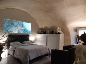um quarto com uma cama e uma televisão na parede em un petit nid douillet em Beauchastel