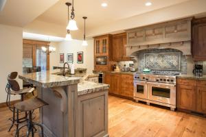 Una cocina con gabinetes de madera y un horno de estufa. en Silver Aspen - Five Bedroom Loft Luxury Townhome Hotel Room, en Solitude