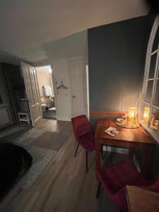 ein Wohnzimmer mit einem Holztisch und roten Stühlen in der Unterkunft B&B De Koog Texel in De Koog