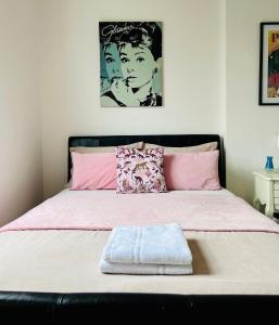 ロンドンにあるGorgeous Studio 15 Minutes from Central Londonのベッドルーム1室(ピンクと白のシーツが備わるベッド1台付)