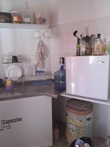 uma cozinha com um balcão e um frigorífico branco em Cómodo departamento en el bajo neuquino em Neuquén
