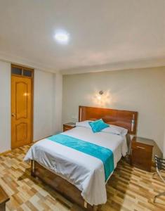 1 dormitorio con 1 cama grande y suelo de madera en Hotel Loyalty Moquegua, en Moquegua