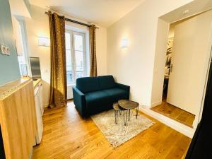 uma sala de estar com um sofá azul e uma mesa em Lovely studio in the Heart of St Germain-des-Prés em Paris