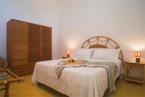 Schlafzimmer mit einem großen Bett mit einem Kopfteil aus Holz in der Unterkunft Oasi Marina Apartment Sea View by Diddoi in Torre Suda