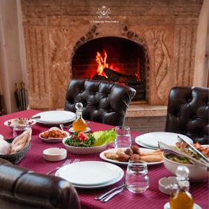 a table with plates of food in front of a fireplace at L'auberge des Emirs in Dayr al Qamar