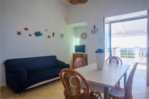 ein Wohnzimmer mit einem Tisch und einem Sofa in der Unterkunft Oasi Marina Apartment Sea View by Diddoi in Torre Suda