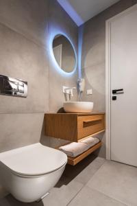 a bathroom with a white toilet and a sink at Myzith Luxury Suites in Keri