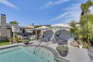 una piscina con sillas y sombrillas junto a una casa en San Diego Hideaway with Private Backyard Oasis!, en San Diego