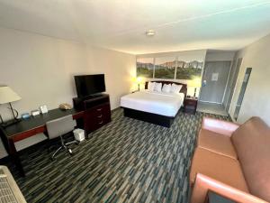 um quarto de hotel com uma cama e um sofá em Days Hotel by Wyndham Mesa Near Phoenix em Mesa