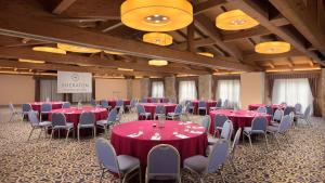 a banquet hall with red tables and chairs in a room at Sheraton Rome Parco de Medici in Rome +79 photos