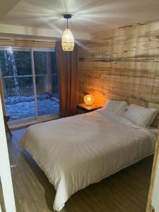 een slaapkamer met een groot wit bed en een raam bij chalet Ani in Piopolis