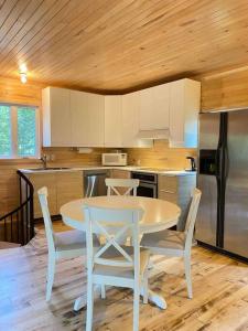 een keuken met een tafel en stoelen en een koelkast bij chalet Ani in Piopolis