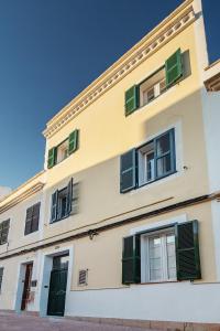 a building with green shuttered windows on it at Xubec - Albergue Juvenil in Ciutadella