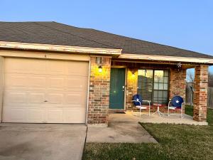 a house with two chairs and a garage at Casa Nicholas , 3 bedroom/ 2 bath with large yard in Killeen
