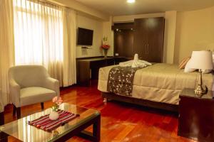 Pokój hotelowy z łóżkiem i krzesłem w obiekcie Group House Apart Hotel w Cuzco